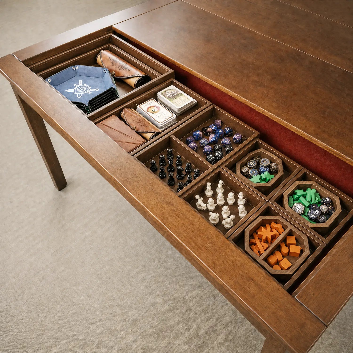 Board game accessories organized inside removable wooden storage compartments