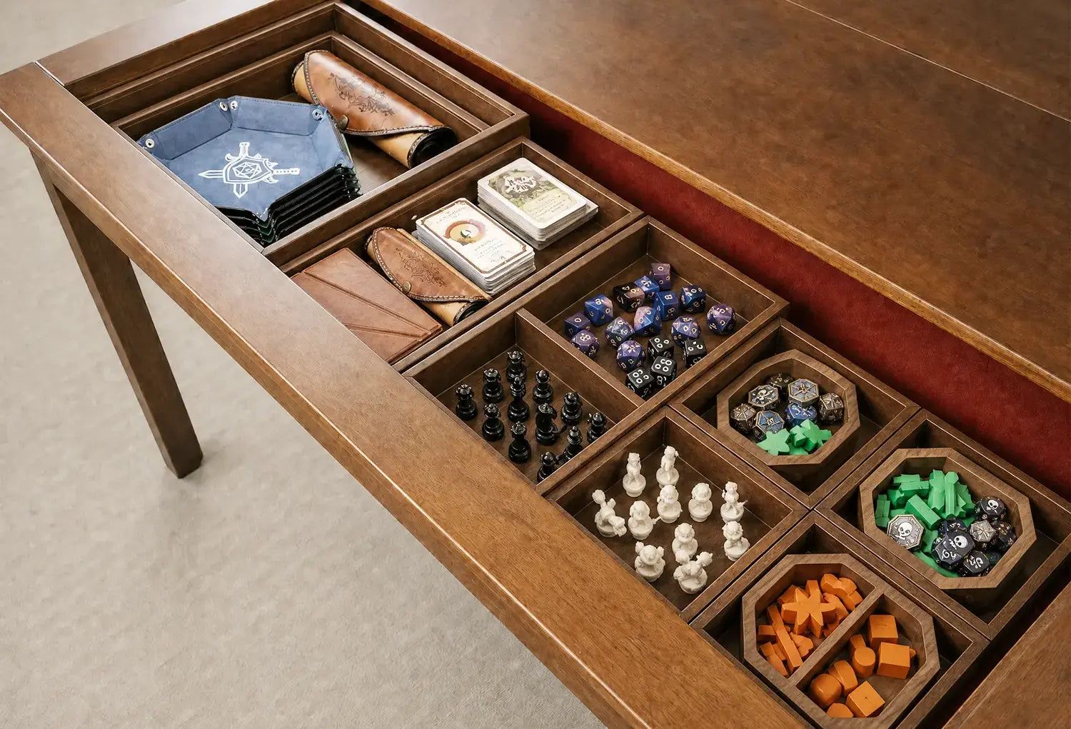 Board game accessories organized inside removable wooden storage compartments