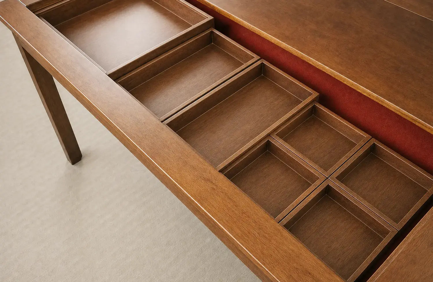 Board game accessories organized inside removable wooden storage compartments