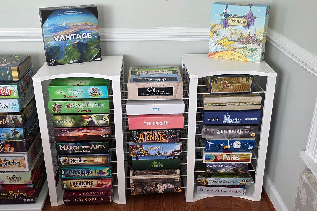 white modular game storage shelves filled with board games, including Vantage, Call of Cthulhu, Warlord Games, Arnan, and Pinks