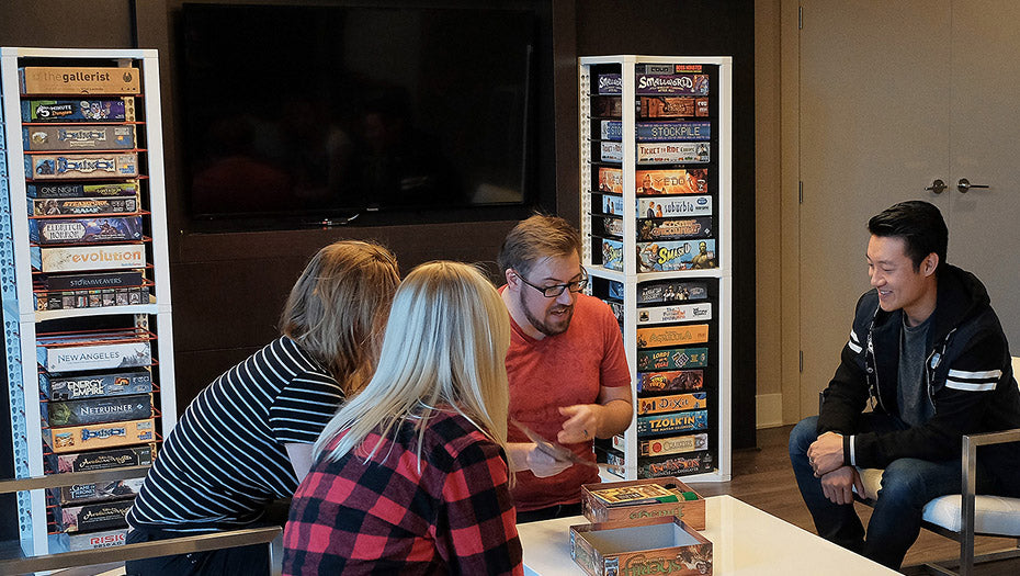 Friends playing board games with tall modular board game storage shelves