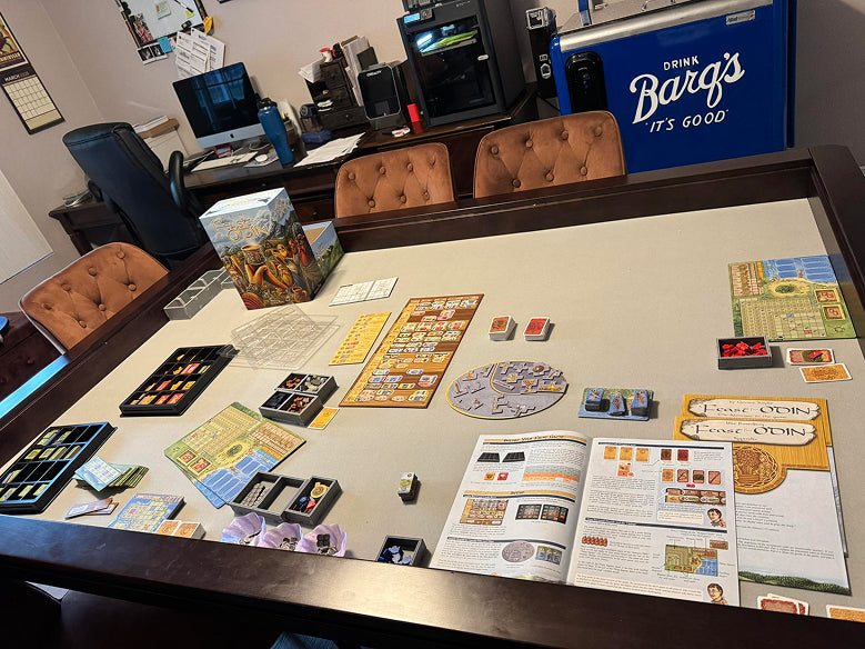 A board game setup on a large table in a home office or lounge area