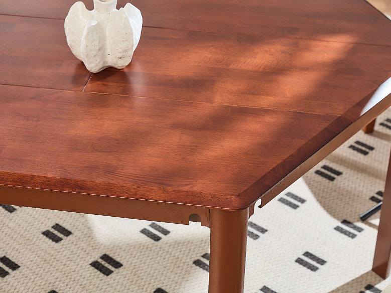 A close-up of a reddish-brown wooden dining table with a visible wood grain finish