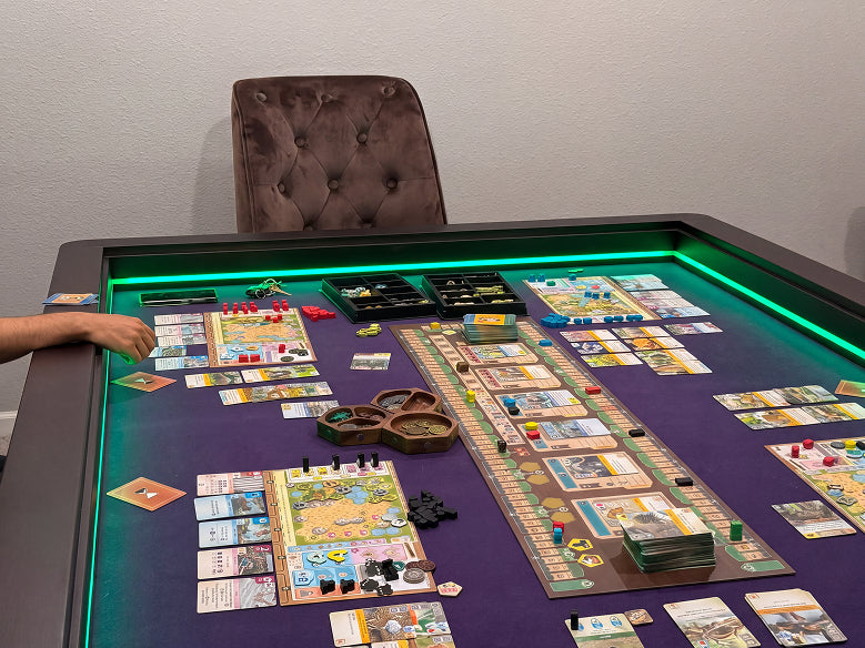 A board game set up on a dark table with a purple playmat