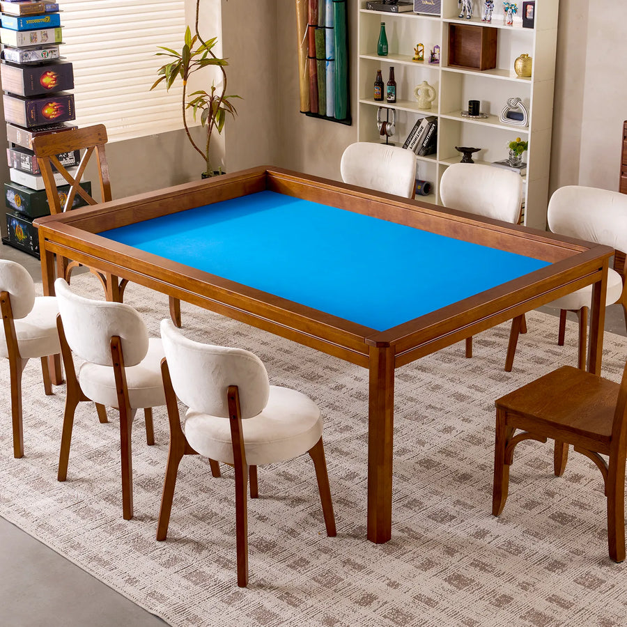 Kingswood 4x6' solid rubberwood game table with a bright blue playing surface and six cream chairs.